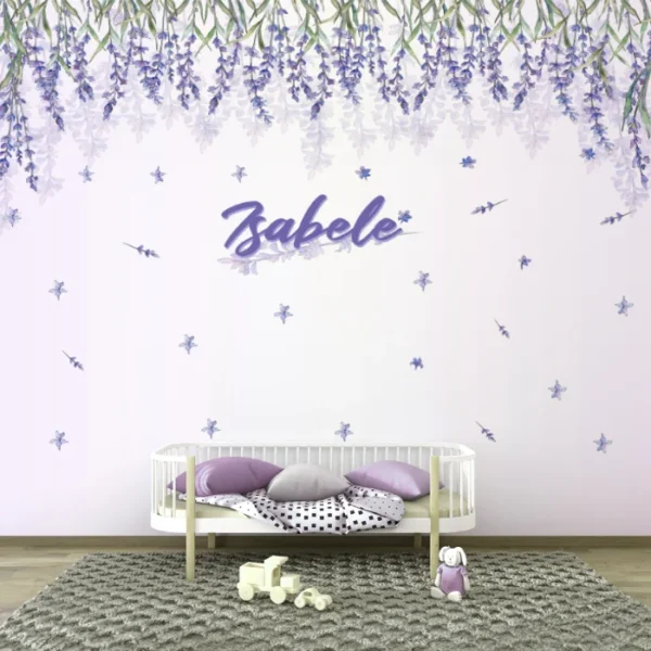Papel de parede floral lilás 'Isabele' decorando um quarto infantil com berço branco, almofadas lilás e brinquedos